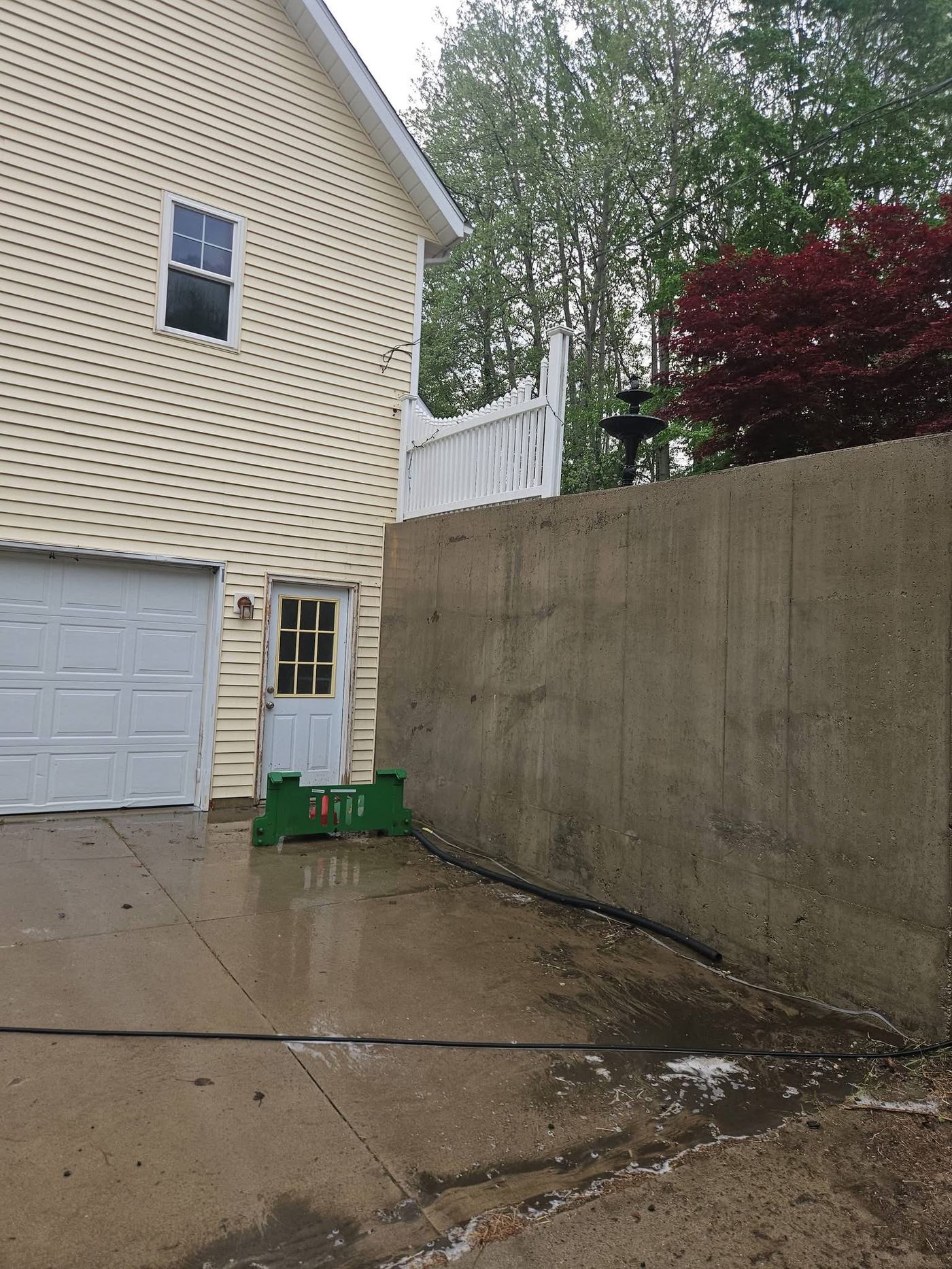 Same concrete retaining wall after soft washing, with mold and algae staining removed